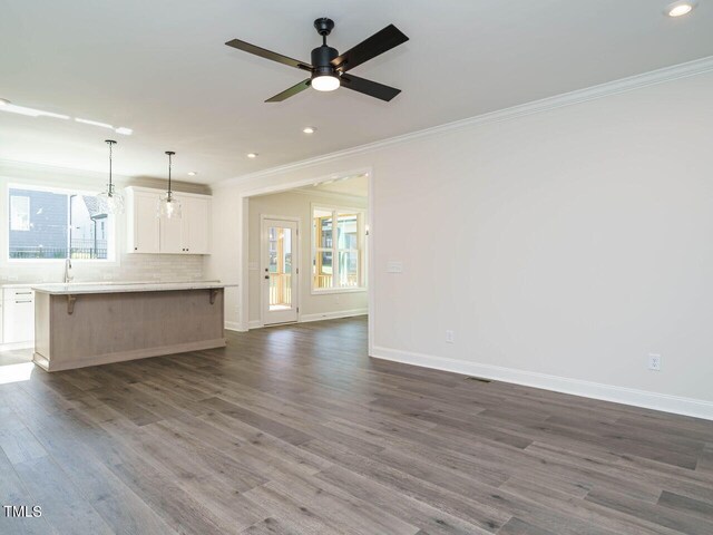 1809 Bright Lantern Way, Wendell, NC 27591 - unfurnished living room featuring ornamental molding, recessed lighting, dark wood-style floors, and a ceiling fan