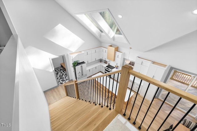 stairs with hardwood / wood-style floors and vaulted ceiling