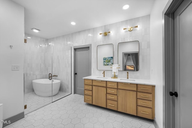 bathroom featuring tile patterned flooring, tile walls, a bathtub, and vanity