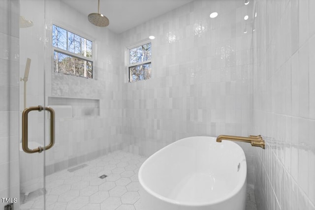 bathroom with tile walls, tile patterned floors, and shower with separate bathtub