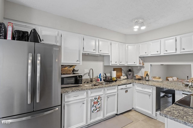 kitchen with stone counters, white cabinets, sink, a textured ceiling, and appliances with stainless steel finishes