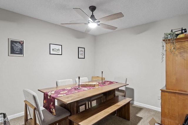 carpeted dining area featuring ceiling fan and a textured ceiling