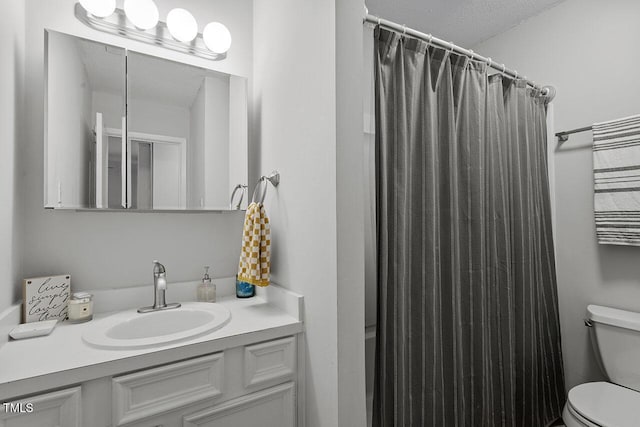 bathroom featuring vanity, a textured ceiling, toilet, and curtained shower