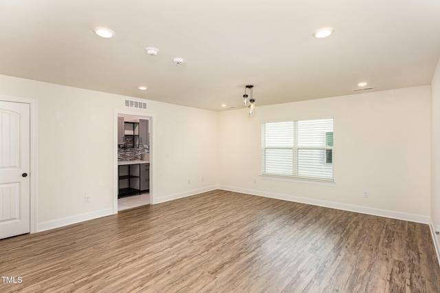 spare room featuring wood-type flooring