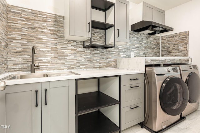 washroom with sink, cabinets, and independent washer and dryer