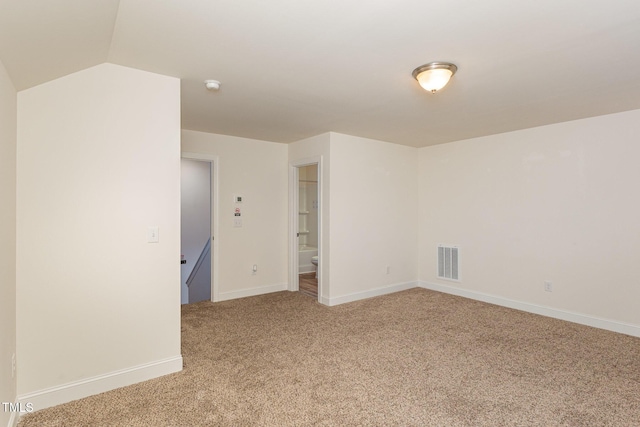 carpeted spare room with lofted ceiling