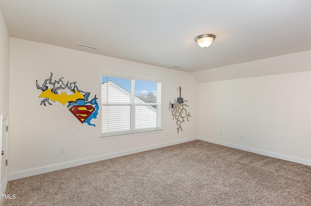 carpeted empty room with lofted ceiling