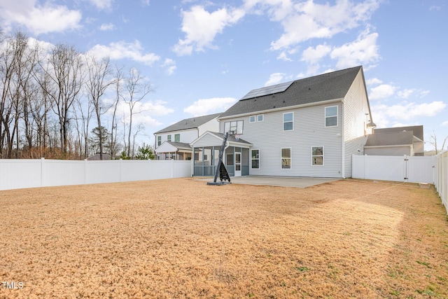 back of house featuring a sunroom, solar panels, and a patio area