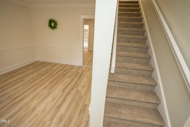 stairway featuring hardwood / wood-style floors and crown molding