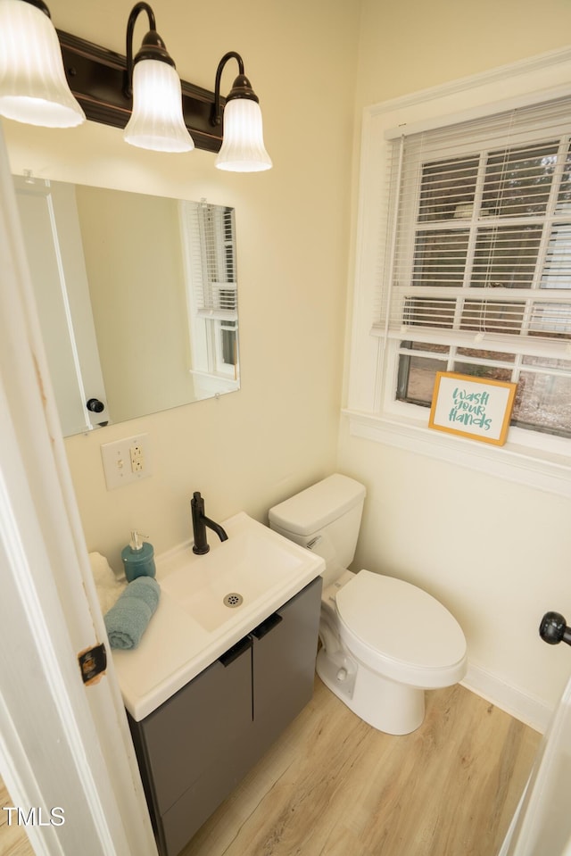 bathroom with hardwood / wood-style flooring, vanity, and toilet