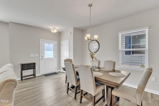 dining space featuring an inviting chandelier and light wood-type flooring