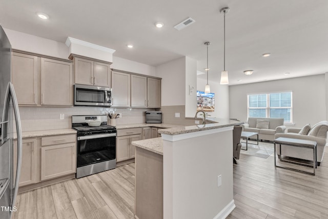 kitchen with kitchen peninsula, decorative backsplash, light stone counters, stainless steel appliances, and pendant lighting