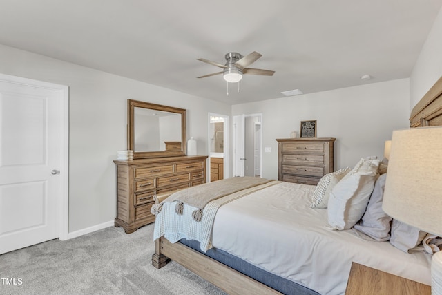 carpeted bedroom with ensuite bath and ceiling fan