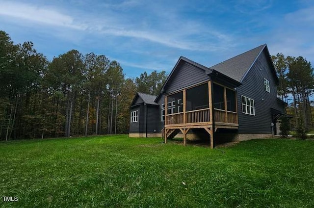 back of property featuring a yard and a sunroom