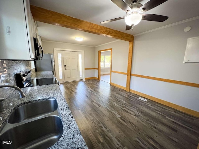 kitchen featuring light stone countertops, appliances with stainless steel finishes, crown molding, and sink