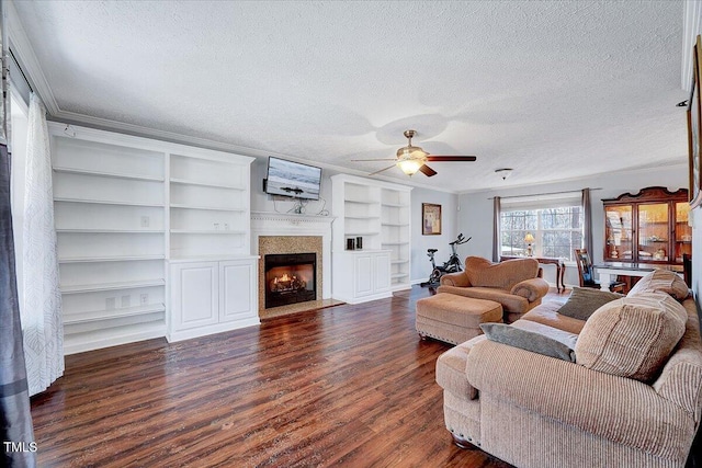 living room with ceiling fan, dark wood-type flooring, ornamental molding, and a textured ceiling