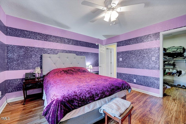 bedroom featuring hardwood / wood-style flooring, a textured ceiling, and ceiling fan