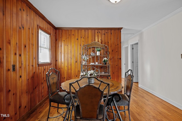 dining room featuring crown molding and light hardwood / wood-style flooring