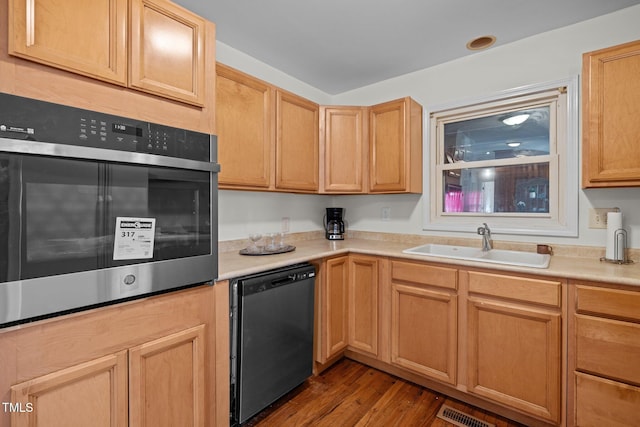 kitchen featuring sink, stainless steel oven, light brown cabinets, light hardwood / wood-style flooring, and dishwashing machine