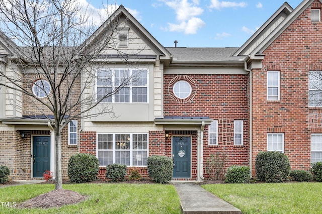 townhome / multi-family property featuring a front lawn