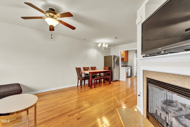 interior space featuring light hardwood / wood-style flooring and ceiling fan with notable chandelier