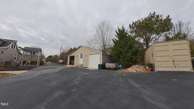 view of property exterior with an outdoor structure and a garage