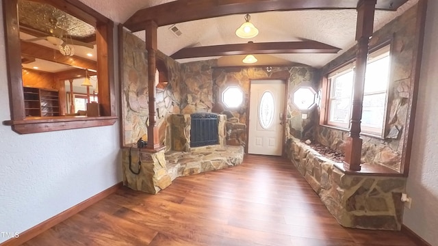 foyer featuring a fireplace, a textured ceiling, lofted ceiling with beams, and hardwood / wood-style flooring