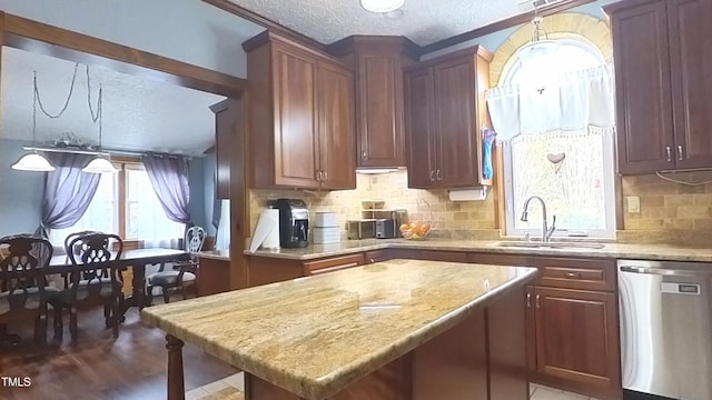 kitchen with tasteful backsplash, sink, a kitchen island, and stainless steel dishwasher