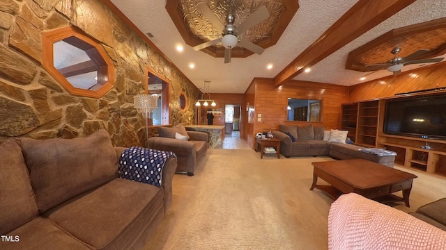 carpeted living room featuring wooden walls, beamed ceiling, a textured ceiling, and ceiling fan