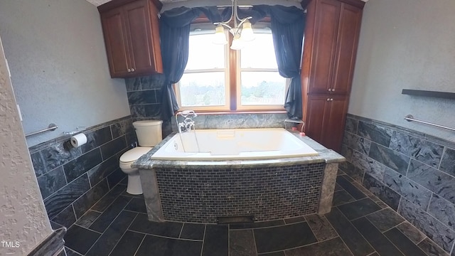 bathroom with toilet, tile walls, and tiled bath