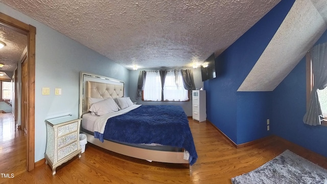 bedroom featuring hardwood / wood-style flooring and a textured ceiling