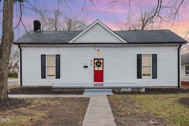 bungalow-style house featuring a shingled roof and a chimney