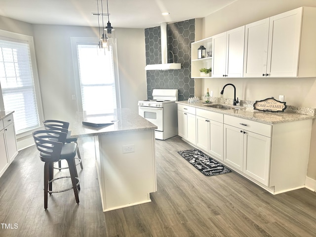 kitchen featuring sink, white cabinetry, light stone counters, pendant lighting, and white range oven