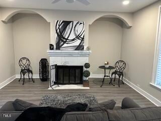 interior space featuring baseboards, wood finished floors, and a glass covered fireplace