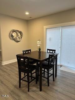 dining space featuring dark wood-type flooring and baseboards