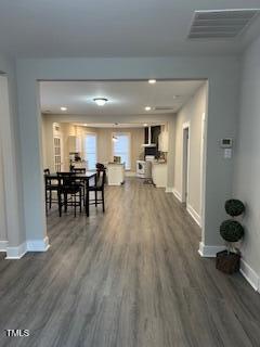 dining space with dark wood-style floors, visible vents, and baseboards