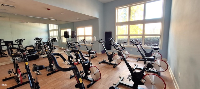 exercise room featuring visible vents, plenty of natural light, and baseboards