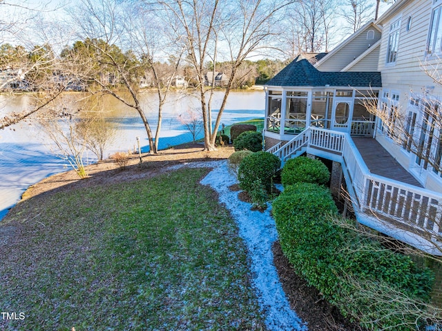 view of yard with a water view, a sunroom, and stairway