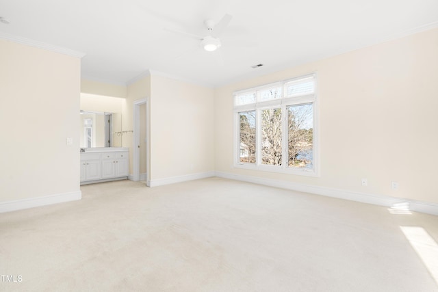 empty room featuring light carpet, crown molding, visible vents, and baseboards