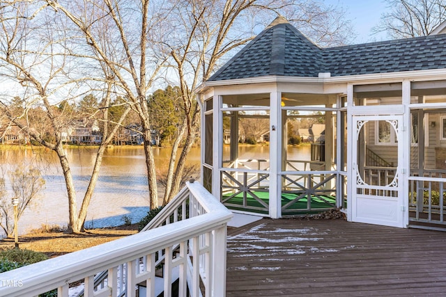 deck with a water view and a sunroom