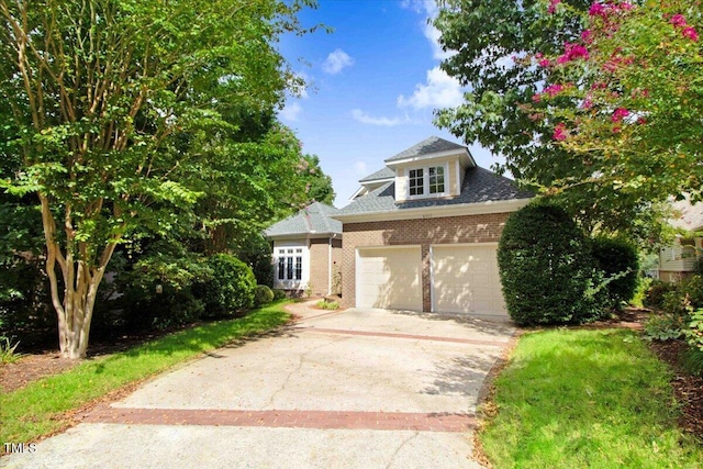 view of front facade featuring driveway, a garage, and brick siding