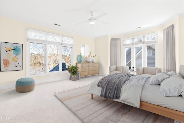 carpeted bedroom featuring a ceiling fan, baseboards, visible vents, and crown molding