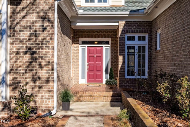 property entrance with brick siding and roof with shingles