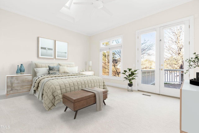 bedroom with light carpet, access to exterior, a skylight, and ornamental molding