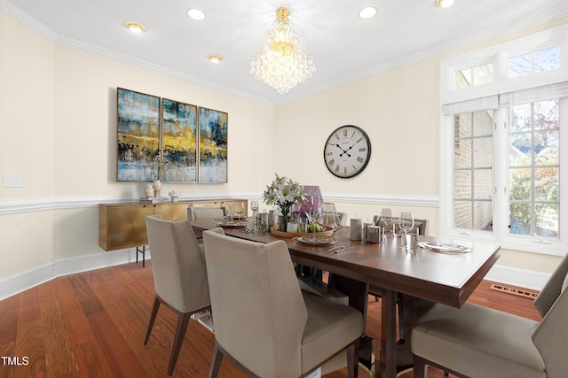 dining room featuring baseboards, ornamental molding, a chandelier, and wood finished floors