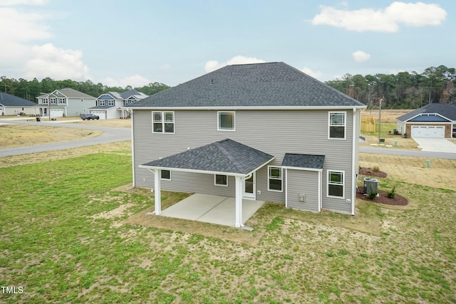 rear view of house featuring a patio area, a yard, and central AC