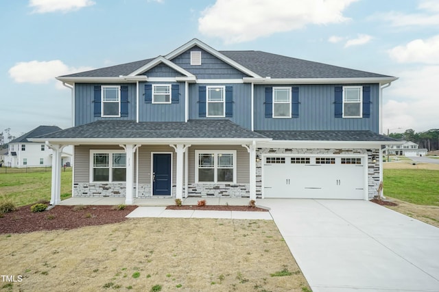 view of front of home with a front lawn, covered porch, and a garage