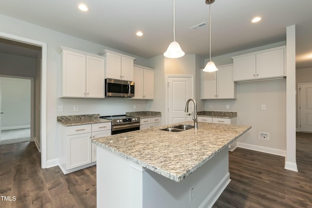 kitchen with white cabinets, sink, stainless steel appliances, and an island with sink