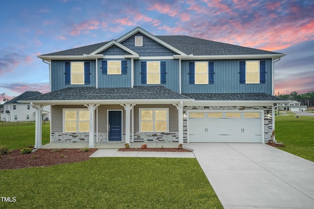 view of front of home with stone siding, board and batten siding, an attached garage, and a lawn