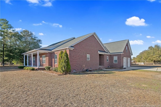 view of property exterior with covered porch and a garage